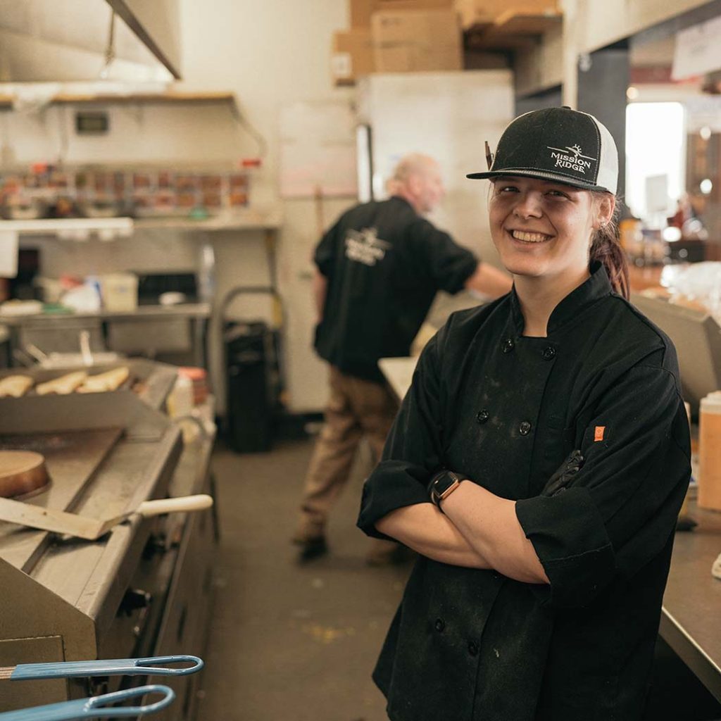 Cook smiling with arms crossed in the kitchen