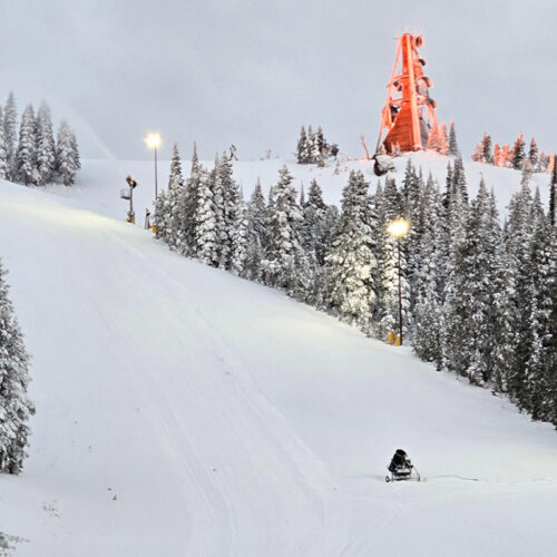 Portable snow gun and tower snow gun on Tumwater run with sunrise behind at Mission Ridge