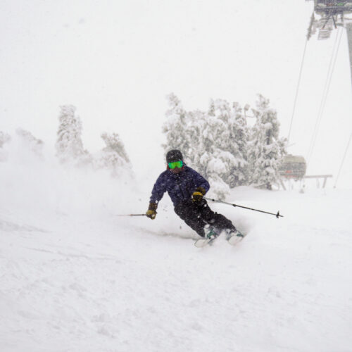 Skier making powder turn under chair 2 in a storm at Mission Ridge.