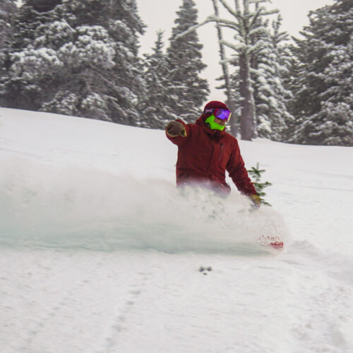 Snowboarder descending the Nertz ski trail at Mission Ridge on a powder day.