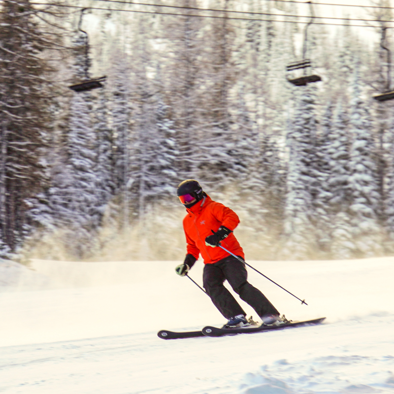 Skier descends Toketie ski trail at Mission Ridge with Chair 3 in the background.