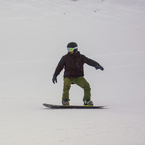 Snowboarder descending the Kiwi trail at Mission Ridge ski area.