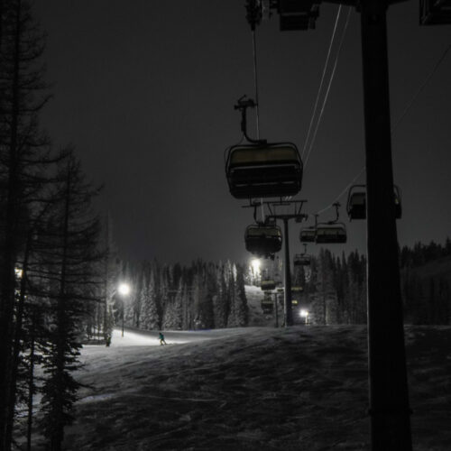 Chair 2 at Mission Ridge at night, with the night skiing lights illuminating the nearby trails and forest.