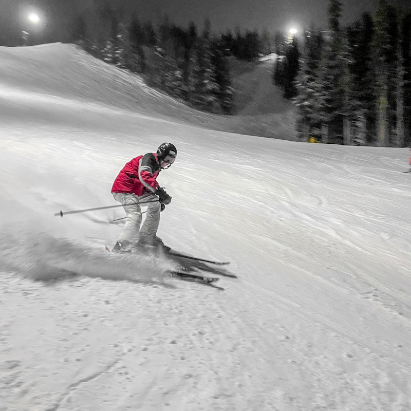 Skier descends Tumwater ski trail at Mission Ridge at night.