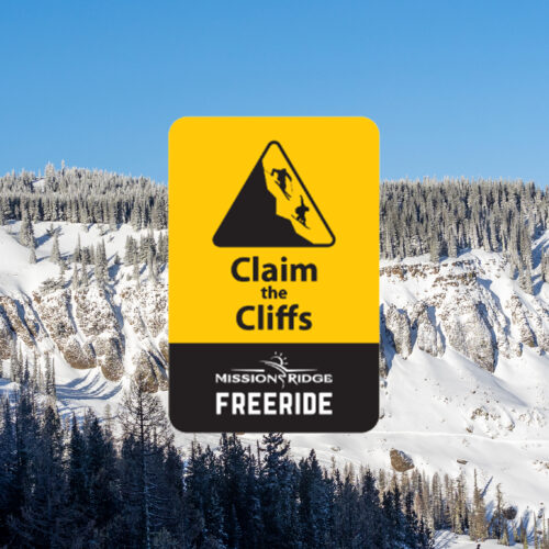 A bold promotional image for Mission Ridge Freeride, featuring a yellow and black sign with the text "Claim the Cliffs" and an illustration of skiers dropping off steep terrain. The background showcases a stunning snow-covered mountain landscape with rugged cliffs and frosted evergreen trees under a clear blue sky, emphasizing the adventurous spirit of freeride skiing and snowboarding.