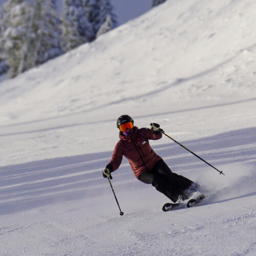 Skier descends Bomber trail at Mission ridge on a sunny morning.