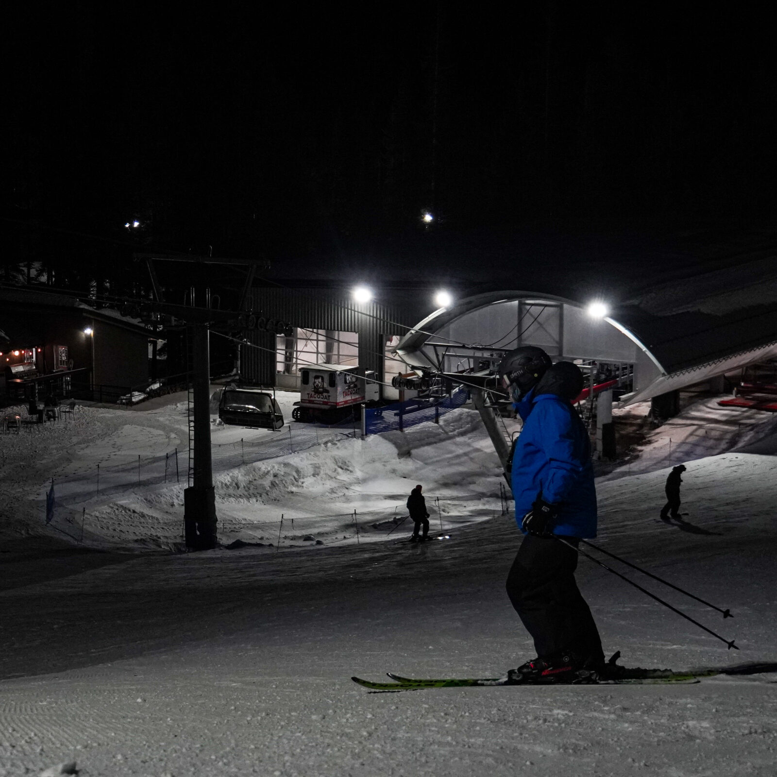 Skiier stands under the lights at mid mountain