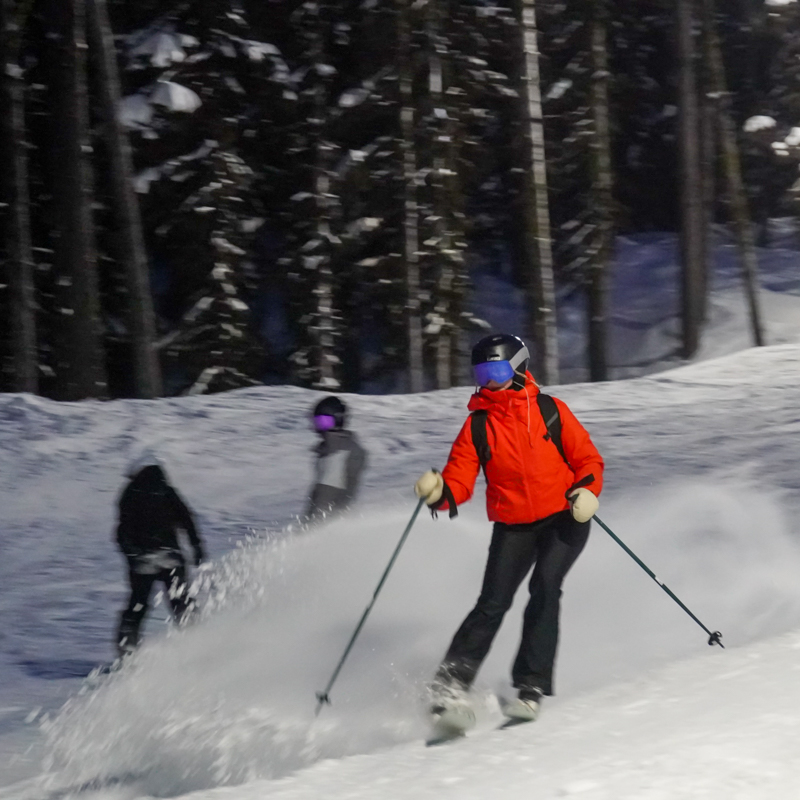 Night skiing with a woman skier