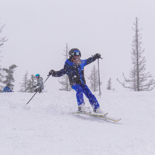 A young skier descends the Hot Dog Hill trail at Mission Ridge on a snowy day.