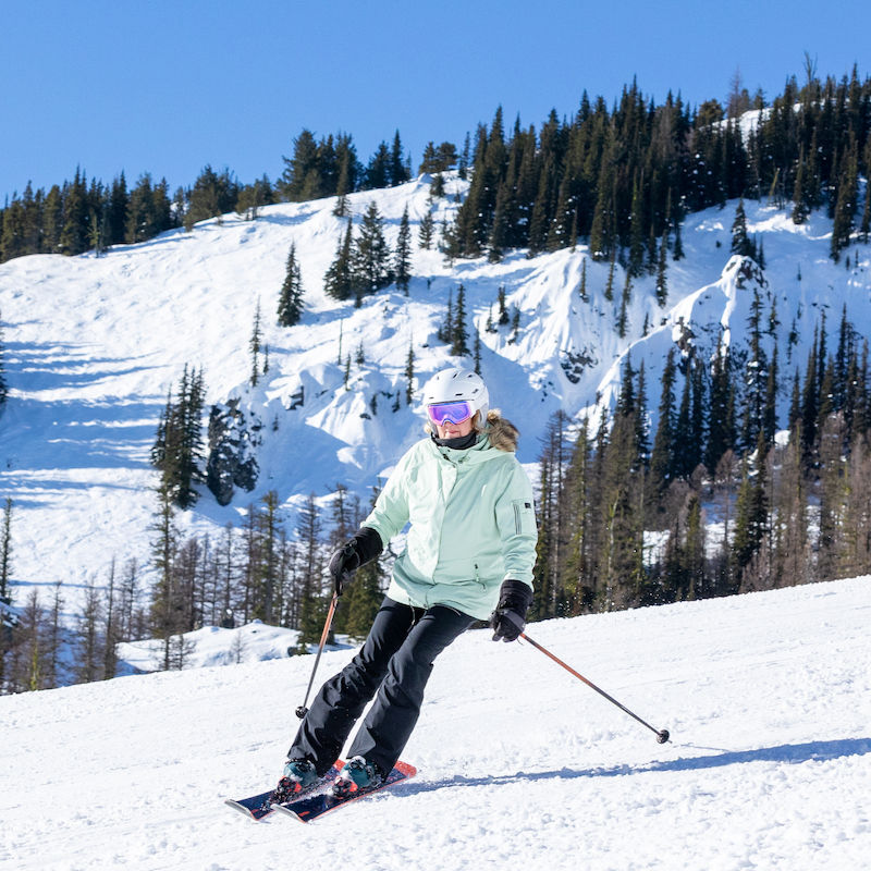 A skier descends a trail at Mission Ridge on a sunny day.