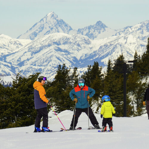 A family chats near the summit of Mission Ridge, with snowy Mt. Stuart in the background.